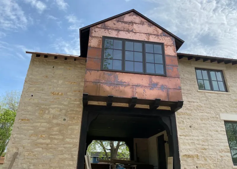 Copper metal panel facade on a stone building for Skylight Installation in Gun Barrel City